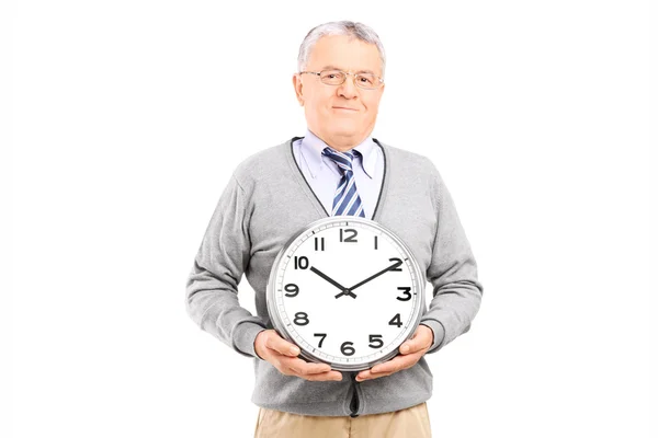 Älterer Herr mit Wanduhr — Stockfoto