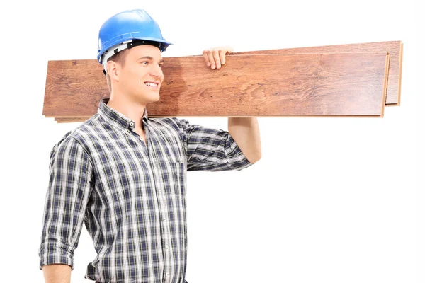 Carpenter carrying couple of planks — Stock Photo, Image