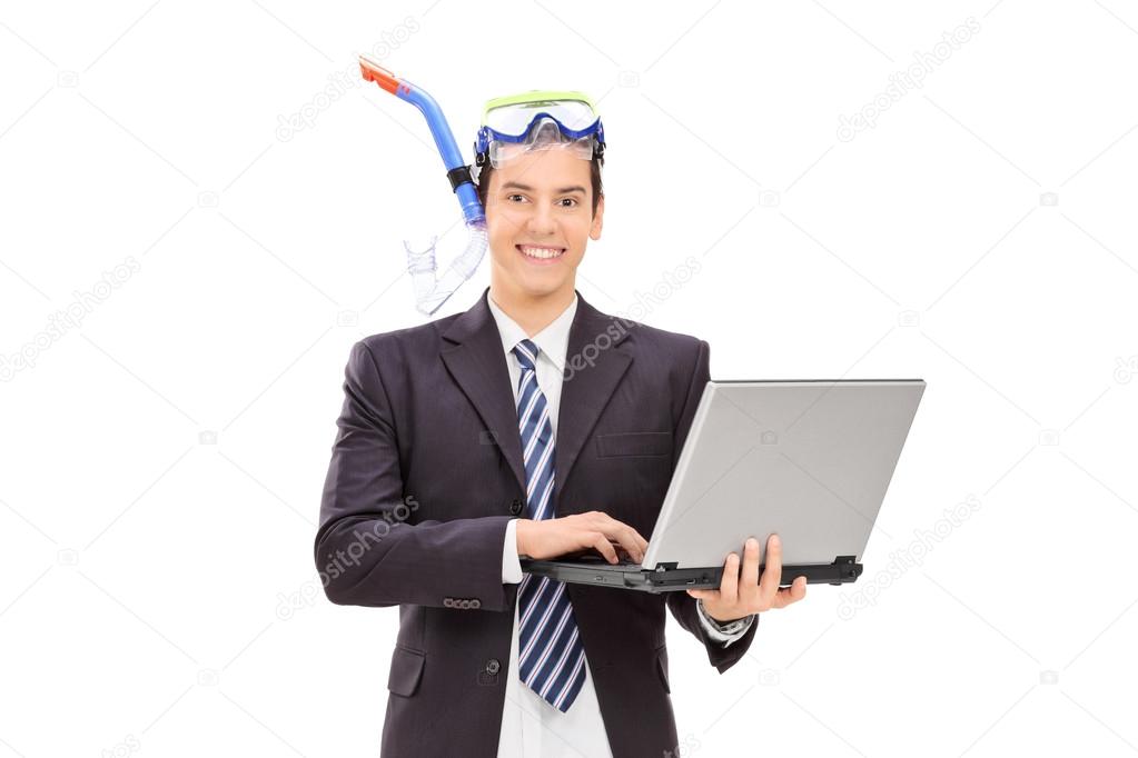 Businessman with diving equipment holding laptop
