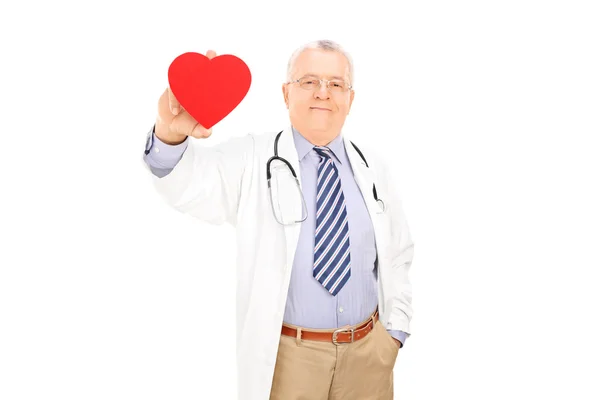 Médico maduro sosteniendo corazón rojo — Foto de Stock