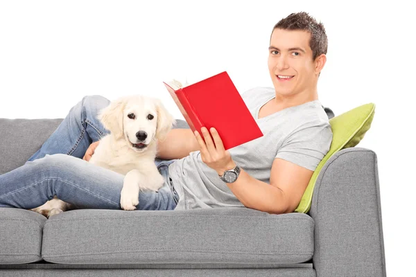 Hombre en sofá con cachorro — Foto de Stock