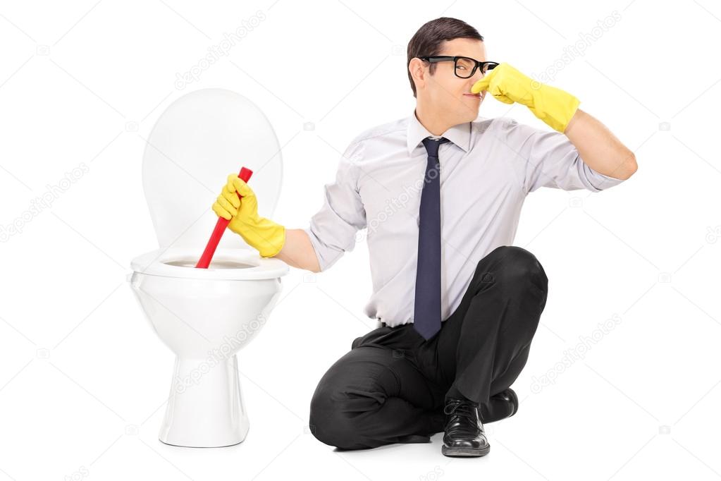Man unclogging toilet with plunger