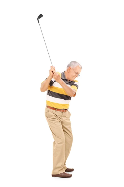 Senior swinging golf club — Stockfoto