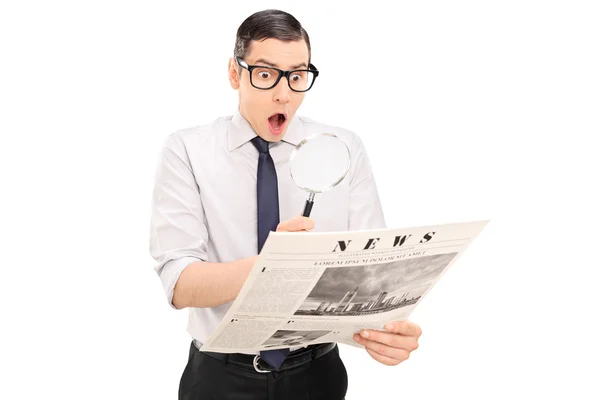 Man reading news through magnifier — Stock Photo, Image