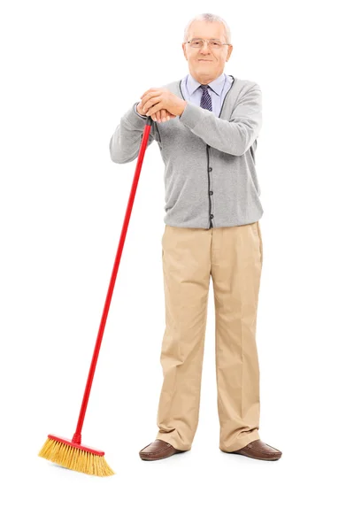 Senior man holding broom — Stock Photo, Image
