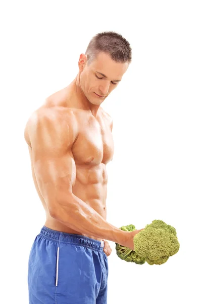 Bodybuilder exercising with broccoli dumbbell — Stock Photo, Image