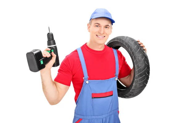 Mechanic holding tire and drill — Stock Photo, Image