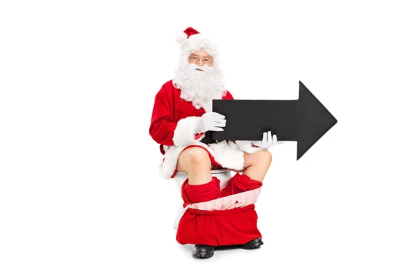 Santa sosteniendo flecha sentada en el inodoro — Foto de Stock