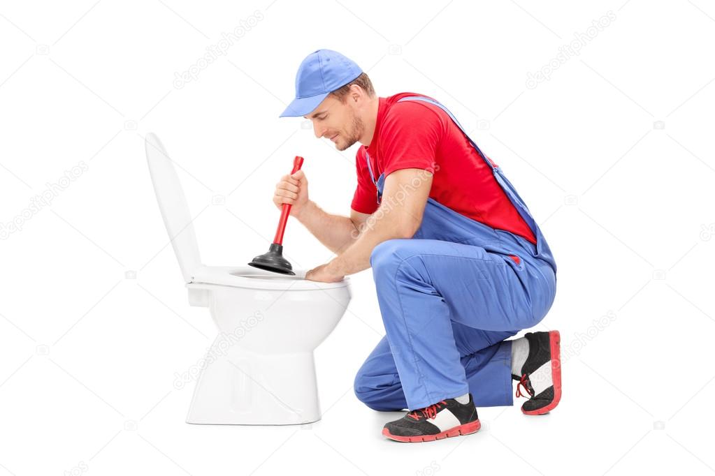 Male plumber working on toilet
