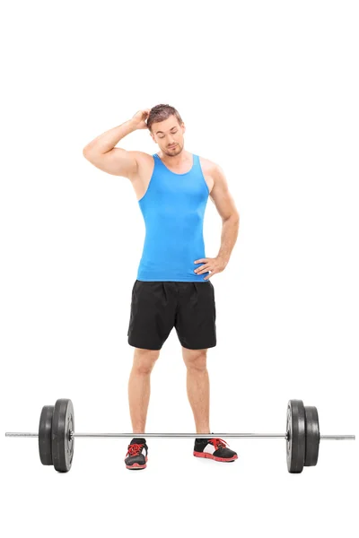 Mannelijke atleet kijken naar barbell — Stockfoto