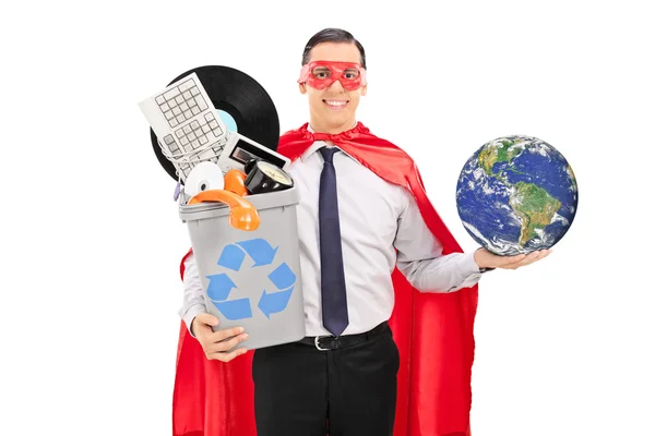Супергерой держит мир и мусорную корзину — стоковое фото