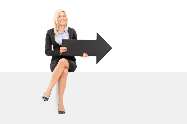 Businesswoman holding black arrow — Stock Photo, Image