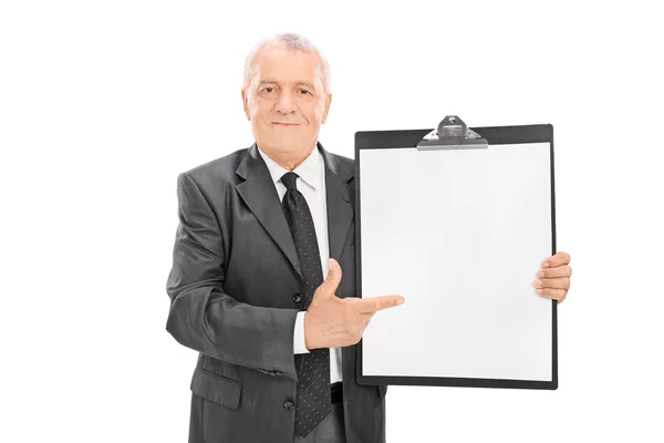 Mature businessman pointing on clipboard — Stock Photo, Image