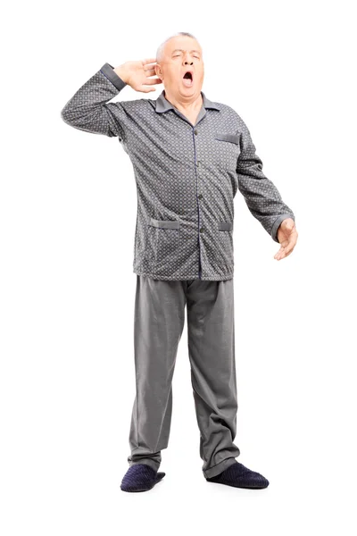 Slaperig senior in pyjama uitrekken — Stockfoto