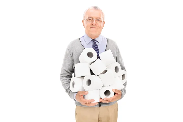 Sénior carregando uma pilha de papel higiênico — Fotografia de Stock