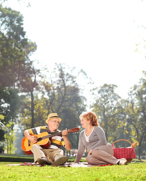 Senior spela gitarr till sin hustru — Stockfoto