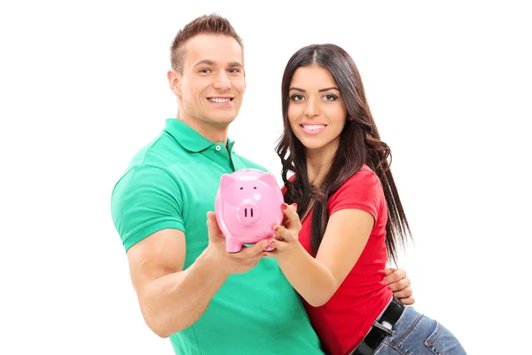 Joven pareja holding piggybank — Foto de Stock