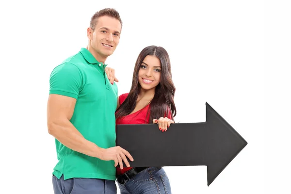 Young couple holding arrow — Stock Photo, Image