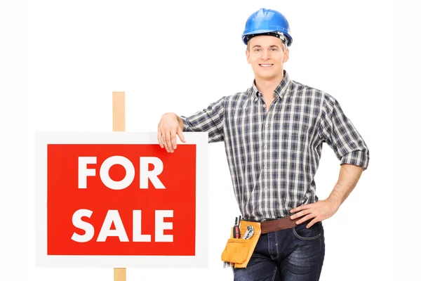 Male repairman leaning on sign — Stock Photo, Image