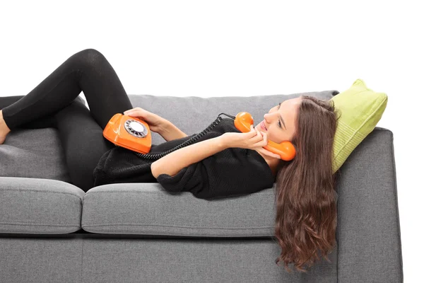 Girl on sofa talking on phone — Stock Photo, Image