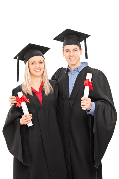 Man and woman in graduation gowns — Stock Photo, Image