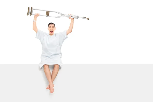 Overjoyed patient raising his crutches — Stock Photo, Image