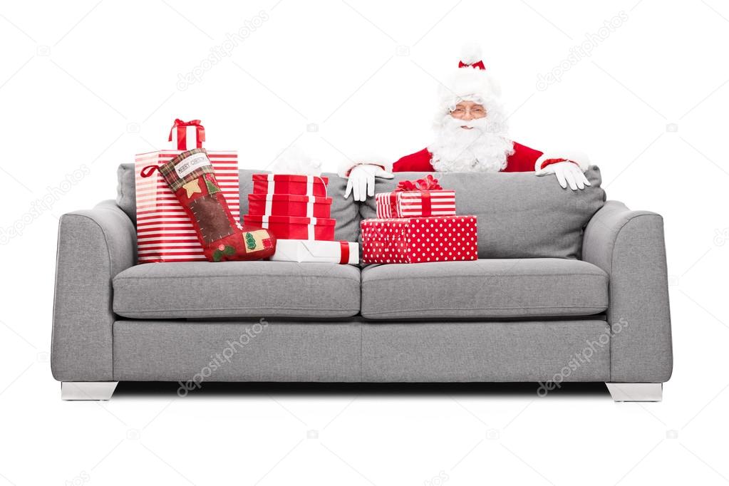 Santa Claus hiding behind sofa
