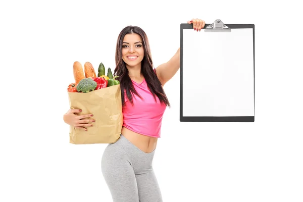 Woman holding grocery bag and clipboard — Stock Photo, Image