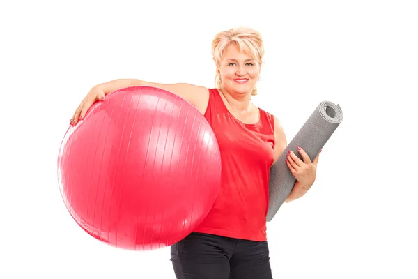 Mulher com bola de fitness e tapete de exercício — Fotografia de Stock