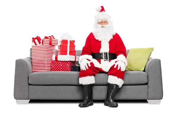 Père Noël sur le canapé plein de cadeaux de Noël — Photo