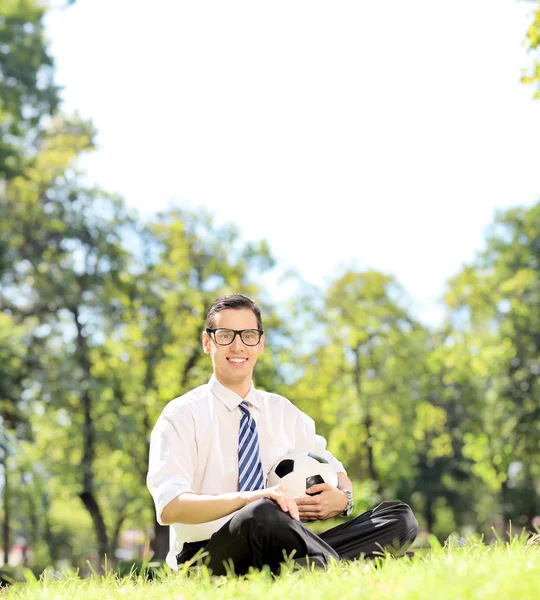Mann hält Fußball im Park — Stockfoto