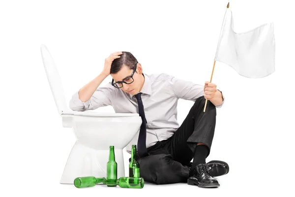 Пьяный мужчина сидит у туалета — стоковое фото