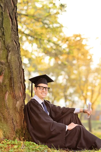 Diplômé du collège assis dans le parc — Photo