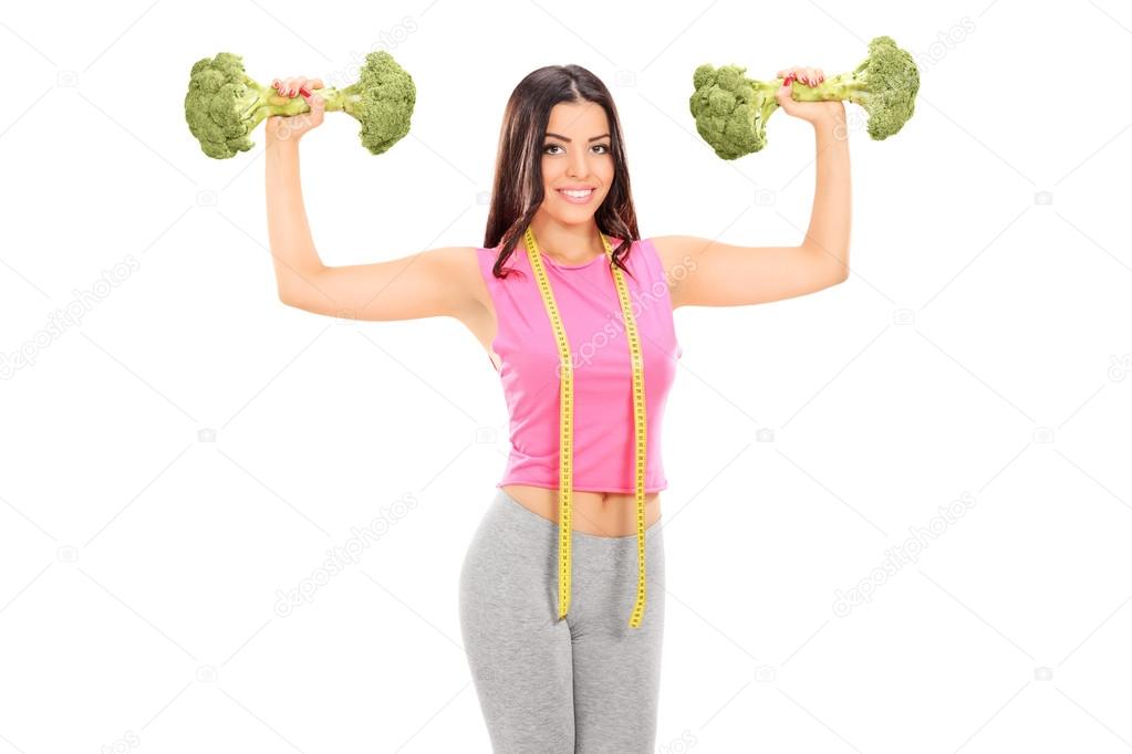Woman holding two broccoli dumbbells