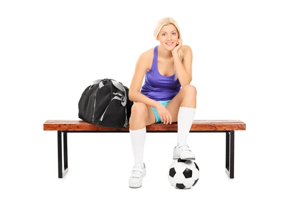 Bankta oturan kadın futbol oyuncusu — Stok fotoğraf