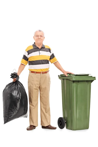 Senior man die tas van trash — Stockfoto