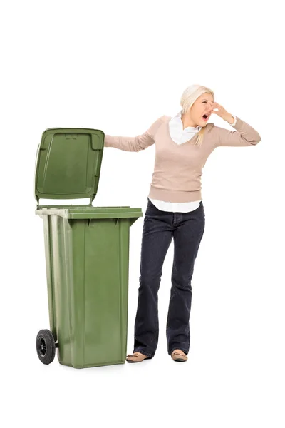 Mulher abrindo lata de lixo fedorento — Fotografia de Stock