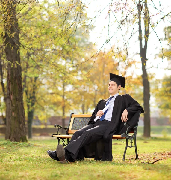 Graduate student holding diploma in park — Stock Photo, Image