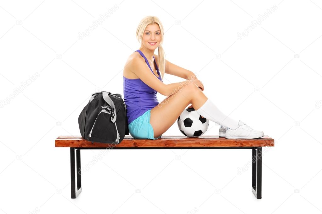 Female football player sitting on bench