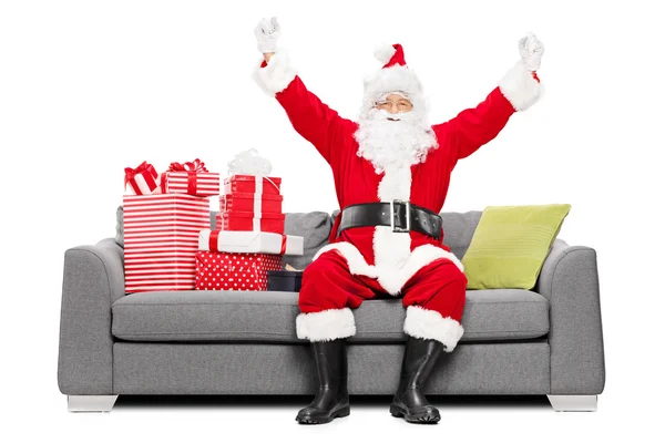 Santa sentado en el sofá con regalos —  Fotos de Stock