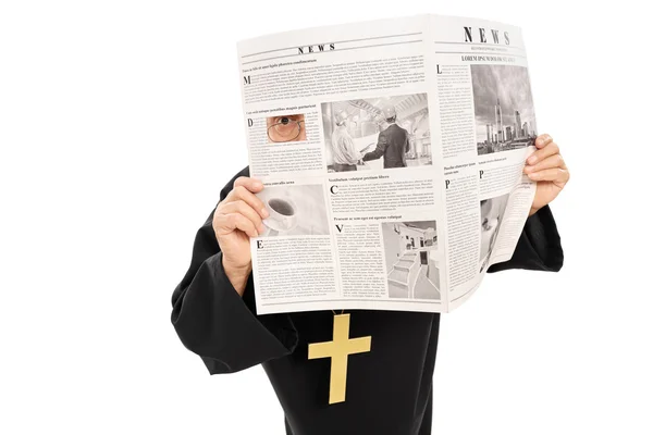 Priester blickt durch Zeitung — Stockfoto