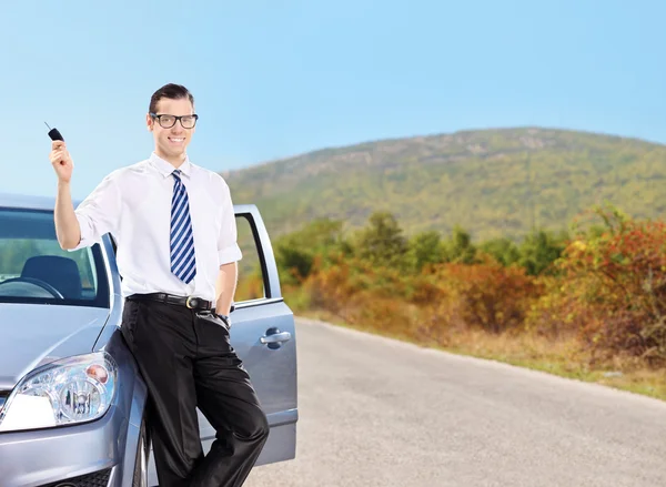 Homem com chave de carro e carro — Fotografia de Stock