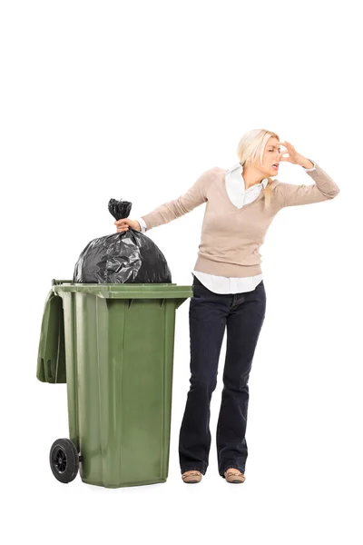 Mulher ao lado da lata de lixo — Fotografia de Stock
