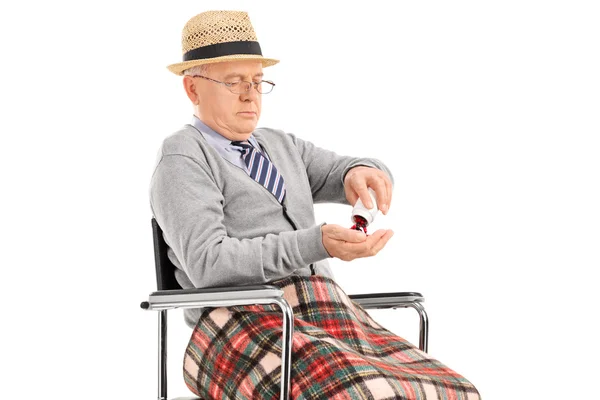 Senior i rullstol holding piller — Stockfoto