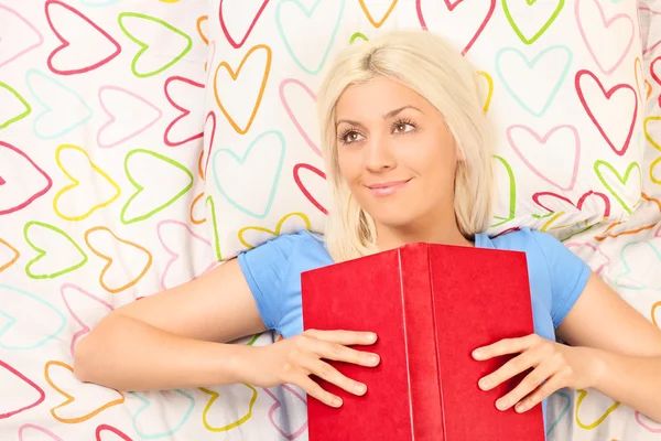 Joyful girl reading book on bed — Stock Photo, Image