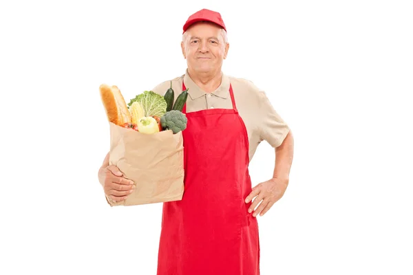 Market vendor holding bag of groceries — Stock Photo, Image
