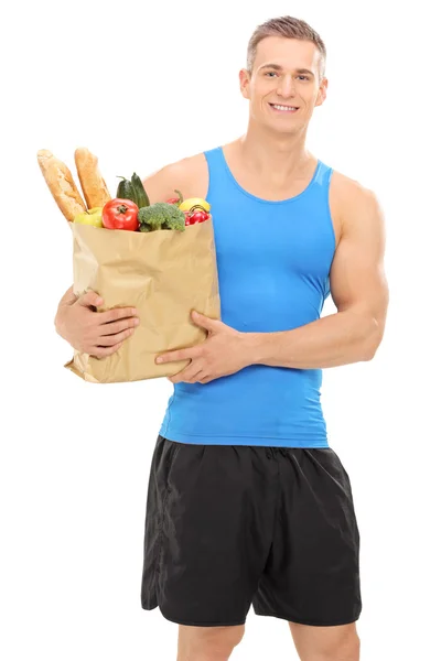 Athlete holding bag full of groceries — Stock Photo, Image