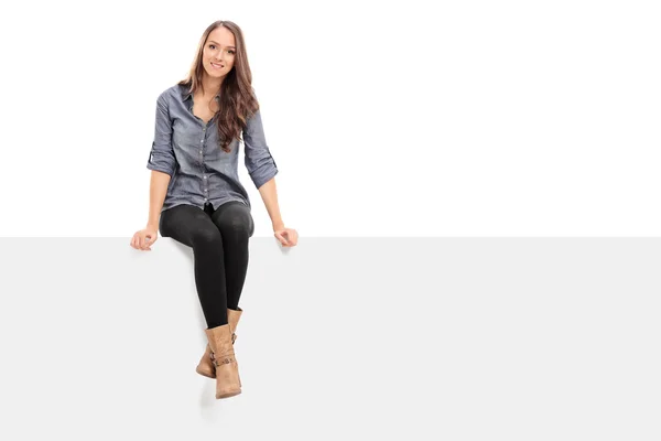 Girl sitting on blank billboard — Stock Photo, Image