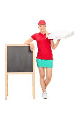 Pizza delivery girl standing by blackboard