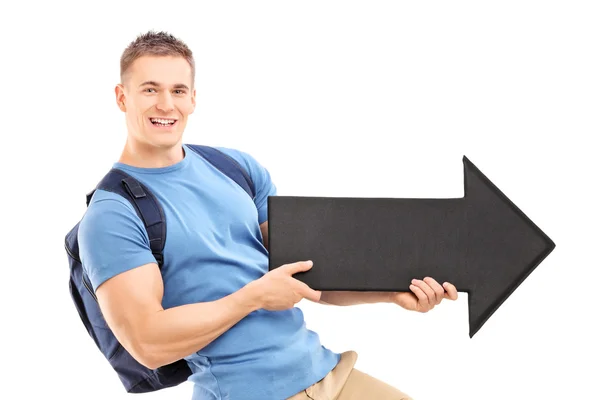 Male student holding black arrow — Stock Photo, Image